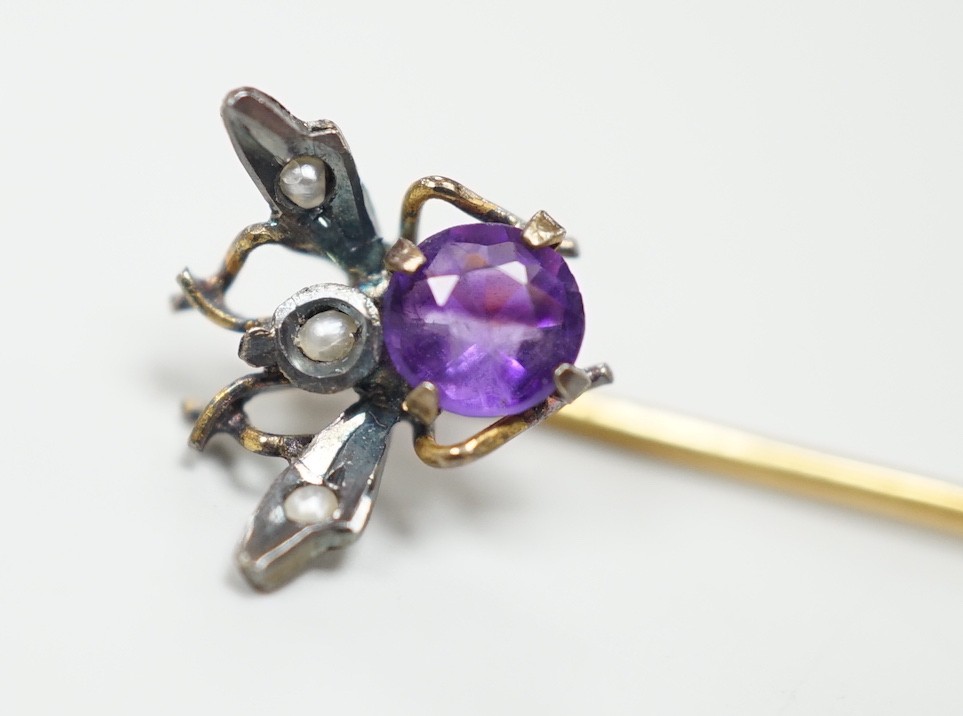An early 20th century yellow and white metal amethyst and seed pearl set bug stick pin, 4mm, gross weight 0.6 grams.